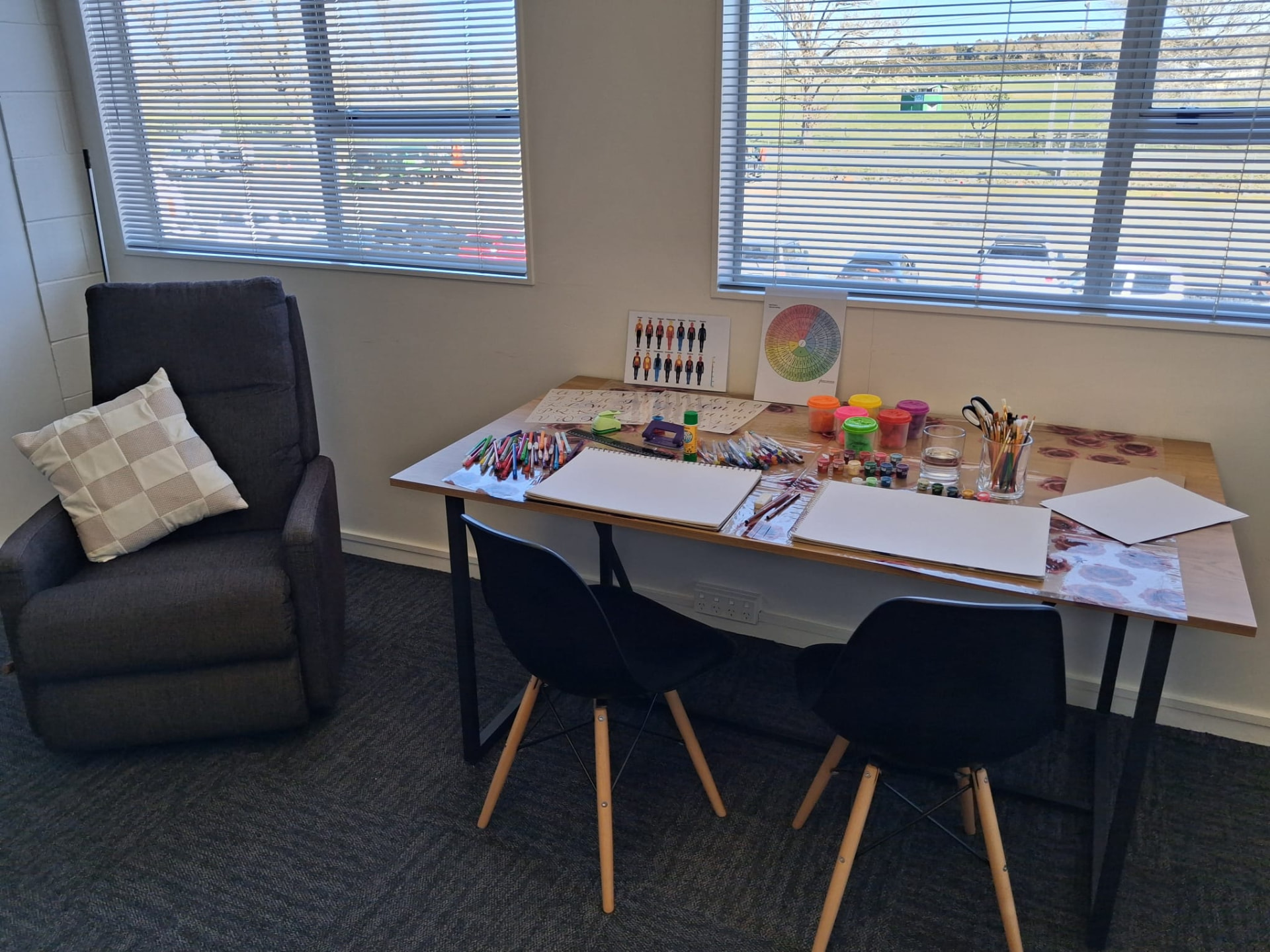 Main therapy table in the Kumeu room with art supplies, paper and drawing tools ready